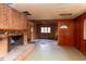 Living room with a brick fireplace, wood-paneled walls, and under-construction ceiling, awaiting renovation at 407 Granville Rd, Chapel Hill, NC 27514