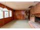 Spacious living room with wood-paneled walls, a fireplace, and large windows for ample natural light at 407 Granville Rd, Chapel Hill, NC 27514