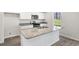 Bright kitchen featuring white cabinets, granite countertops, stainless steel appliances, and a center island at 413 Citron St, Sanford, NC 27332
