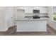 Kitchen with white cabinets, granite countertops, stainless appliances, and a central island with a sink at 413 Citron St, Sanford, NC 27332