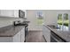 Modern kitchen with white cabinets, granite countertops, stainless appliances, and a window overlooking the backyard at 413 Citron St, Sanford, NC 27332