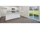 Kitchen with an island, stainless steel appliances, white cabinets, and a sliding glass door leading to the patio at 413 Citron St, Sanford, NC 27332