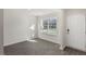 Bright living room featuring gray vinyl floors, a large window with a view of the front yard, and a white entry door at 413 Citron St, Sanford, NC 27332