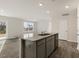 Open kitchen featuring a central island with a sink and views into the living room with outdoor access at 417 Citron St, Sanford, NC 27332