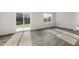 Bright living room with sliding glass doors to the outside and a window, showcasing the new vinyl plank flooring at 417 Citron St, Sanford, NC 27332