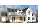 Charming white farmhouse with black roof, covered porch, and manicured landscaping at 431 Fieldstone Ln, Pittsboro, NC 27312
