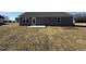 Rear exterior of a house with gray siding, a patio, and expansive grassy backyard at 44 Harvest Hills Ln, Dunn, NC 28334