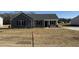 Charming one-story home featuring gray siding, black shutters, covered entry, and a well-manicured lawn at 44 Harvest Hills Ln, Dunn, NC 28334