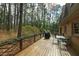 Wood back deck with furniture and grill overlooks a lush wooded backyard at 5008 Hermitage Dr, Raleigh, NC 27612
