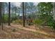 Backyard view of the home and deck surrounded by mature trees and natural landscaping at 5008 Hermitage Dr, Raleigh, NC 27612