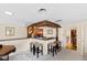 Basement bar area with four stools, brick accents, wood trim, and access to living area at 5008 Hermitage Dr, Raleigh, NC 27612