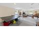 Spacious finished basement with a ping pong table, seating areas, and natural light at 5008 Hermitage Dr, Raleigh, NC 27612