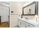 Elegant bathroom with a white vanity, decorative mirror, and updated fixtures at 5008 Hermitage Dr, Raleigh, NC 27612