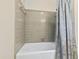 Clean bathroom with a white bathtub and neutral tile surround with a shower at 5008 Hermitage Dr, Raleigh, NC 27612