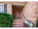 Inviting brick-paved front entrance with a cozy bench seat and lush greenery at 5008 Hermitage Dr, Raleigh, NC 27612