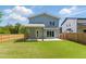 Grassy backyard featuring a covered patio and sliding glass doors with an outdoor seating area at 505 Colleton Rd, Raleigh, NC 27610