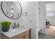 Modern bathroom featuring a vanity with a round mirror, adjacent to a seating nook and doorway at 505 Colleton Rd, Raleigh, NC 27610