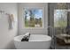 Bathroom with a free-standing tub, glass shower, and a large window at 505 Colleton Rd, Raleigh, NC 27610