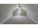 Attic space featuring a high ceiling, a ceiling fan, and a window overlooking the yard at 55 Cherry Bark Dr, Youngsville, NC 27596