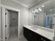 Bathroom with a large mirror over the vanity, and a view of the bathtub with tile surround at 55 Cherry Bark Dr, Youngsville, NC 27596