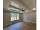 Large bedroom with tray ceiling, ceiling fan, and bright window overlooking backyard at 55 Cherry Bark Dr, Youngsville, NC 27596