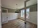 Bright dining room with elegant chandelier, hardwood floors, and natural light from large windows at 55 Cherry Bark Dr, Youngsville, NC 27596
