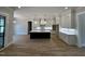 Open-concept kitchen featuring a large island, custom cabinetry, and hardwood floors at 55 Cherry Bark Dr, Youngsville, NC 27596