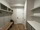 Mudroom featuring a bench with hooks, white cabinets, and bright white walls at 55 Cherry Bark Dr, Youngsville, NC 27596