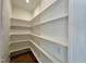 Well-organized pantry with white shelving units and hardwood floors, offering ample storage space at 55 Cherry Bark Dr, Youngsville, NC 27596