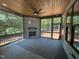 Screened porch featuring a ceiling fan, brick fireplace, and views of the private backyard at 55 Cherry Bark Dr, Youngsville, NC 27596