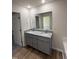 Bathroom featuring double sinks, granite counters, gray cabinets, and hardwood floors at 73 Phil Jack Rd, Dunn, NC 28334