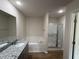 Bathroom featuring a soaking tub, glass shower, and granite countertop at 73 Phil Jack Rd, Dunn, NC 28334