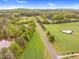 An aerial view features a road stretching through fields, ponds, and woodlands under a blue sky at 749 Bowden Rd, Chapel Hill, NC 27516