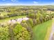 An aerial view features a serene landscape with a pond, trees, and vibrant greenery at 749 Bowden Rd, Chapel Hill, NC 27516
