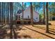 Landscaped backyard featuring mature trees, a patio, deck, and screened porch with outdoor seating at 749 Bowden Rd, Chapel Hill, NC 27516