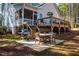 View of the home's back exterior featuring a screened porch, deck, and patio with outdoor seating at 749 Bowden Rd, Chapel Hill, NC 27516