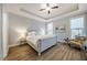 Cozy bedroom featuring a ceiling fan, tray ceiling, wood floors, and neutral decor at 749 Bowden Rd, Chapel Hill, NC 27516