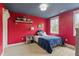 Colorful bedroom with red walls, blue ceiling, and decor shelves at 749 Bowden Rd, Chapel Hill, NC 27516