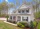 Stunning two-story home with stone accents and gray siding nestled among tall pine trees in a picturesque setting at 749 Bowden Rd, Chapel Hill, NC 27516