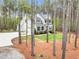 Charming two-story home with a stone facade and gray siding, surrounded by tall pine trees and lush greenery at 749 Bowden Rd, Chapel Hill, NC 27516