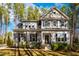 Charming two-story home with stone accents, black shutters, lush landscaping, and a well-manicured lawn at 749 Bowden Rd, Chapel Hill, NC 27516