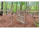 A charming wooden gate and wire fence encloses the property's serene wooded area at 749 Bowden Rd, Chapel Hill, NC 27516