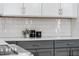 Stylish kitchen with white tile backsplash, grey cabinets and quartz countertops at 749 Bowden Rd, Chapel Hill, NC 27516