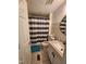 Full bathroom with a shower and tub combination, tiled flooring, vanity, and a navy striped shower curtain at 88 Barnes Rd, Middlesex, NC 27557