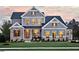 Charming two-story home with gray siding, stone accents, well-manicured lawn, and inviting front porch at , Efland, NC 27243