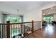Bright upstairs hallway boasting hardwood floors, iron railings, and glimpses of a cozy downstairs seating area at , Efland, NC 27243