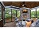 Inviting screened porch with a stone fireplace, comfortable seating, and views of the surrounding trees at , Efland, NC 27243