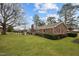 Spacious green backyard featuring a brick home with a patio area, ideal for relaxation and outdoor enjoyment at 102 Trinity Dr, Elon, NC 27244