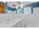 Bathroom featuring double sinks, all-white tile and floral patterned wallpaper at 102 Trinity Dr, Elon, NC 27244