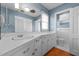 Bathroom with white cabinets, a large mirror, and a separate toilet area at 102 Trinity Dr, Elon, NC 27244